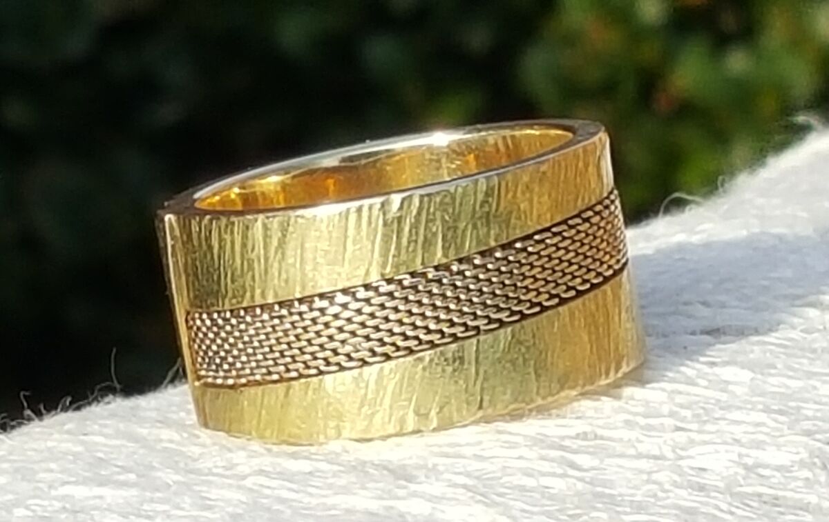 Brede gehamerde gouden ring met een ingewerkt geweven bandje