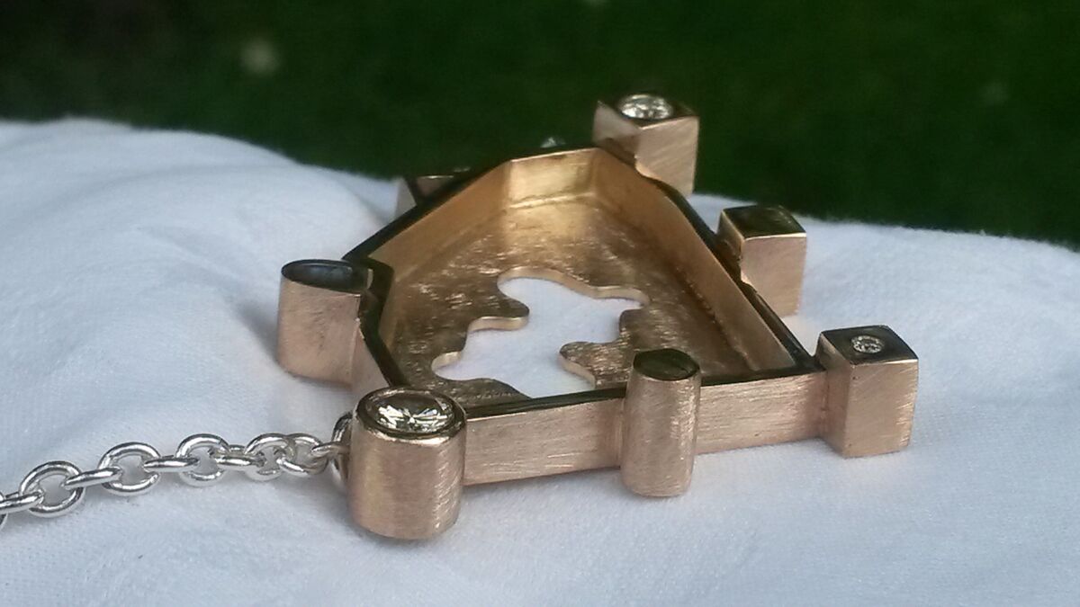 Gouden hanger met de contouren van een kasteel en kleine diamantjes