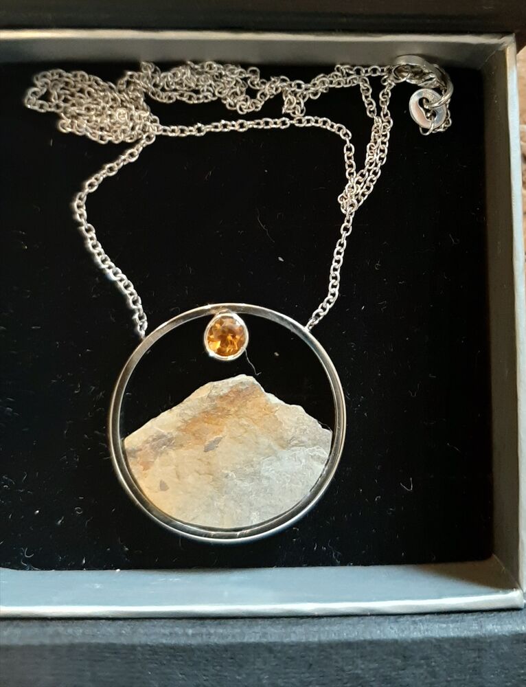 Hanger met een ruwe, ongepolijste steen omlijst door zilver, met een kleine citrien