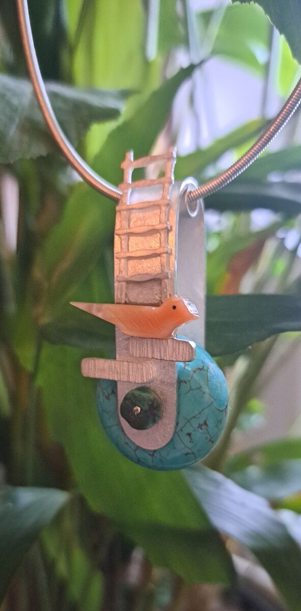Hanger met een ladder, een oranje vogeltje en een ronde turkooizen steen